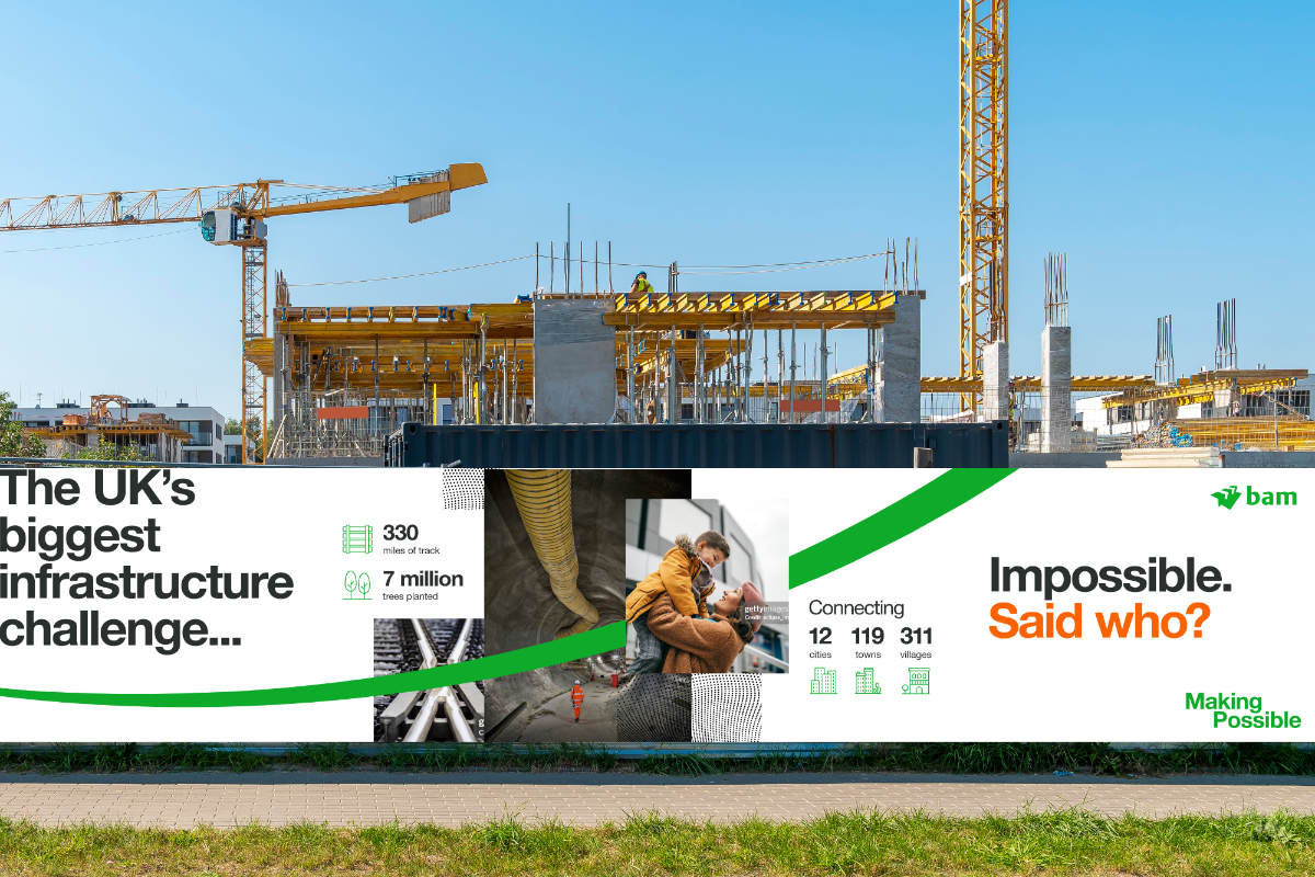 Construction site with cranes, scaffolding, and a large banner. The banner reads: